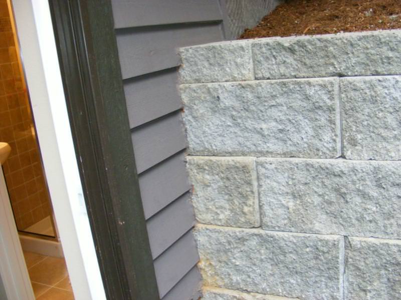 Retaining wall installed over the top of the siding